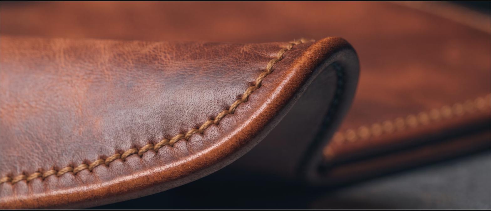 Close-up of saddle stitching and burnished edge on a thick leather sheath